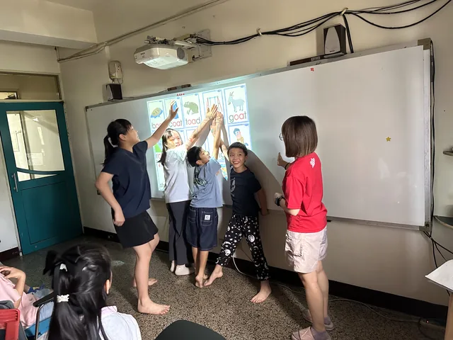孩子在老師鼓勵下合作完成英語課堂挑戰